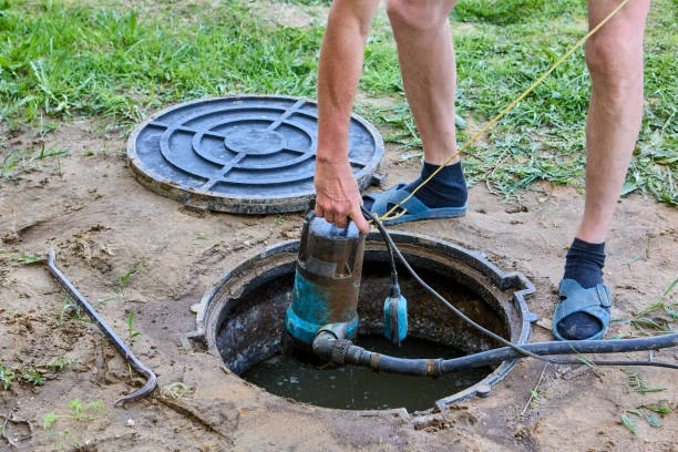 Plumber installing Zoeller submersible cast iron sump pump and check valve in Hartselle AL